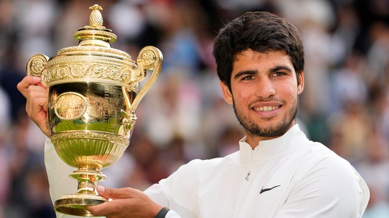 Spain's Carlos Alcaraz celebrates with the trophy after beating Serbia's Novak Djokovic to win the final of the men's singles on day fourteen of the Wimbledon tennis championships in London, Sunday, July 16, 2023. (AP Photo/Kirsty Wigglesworth)